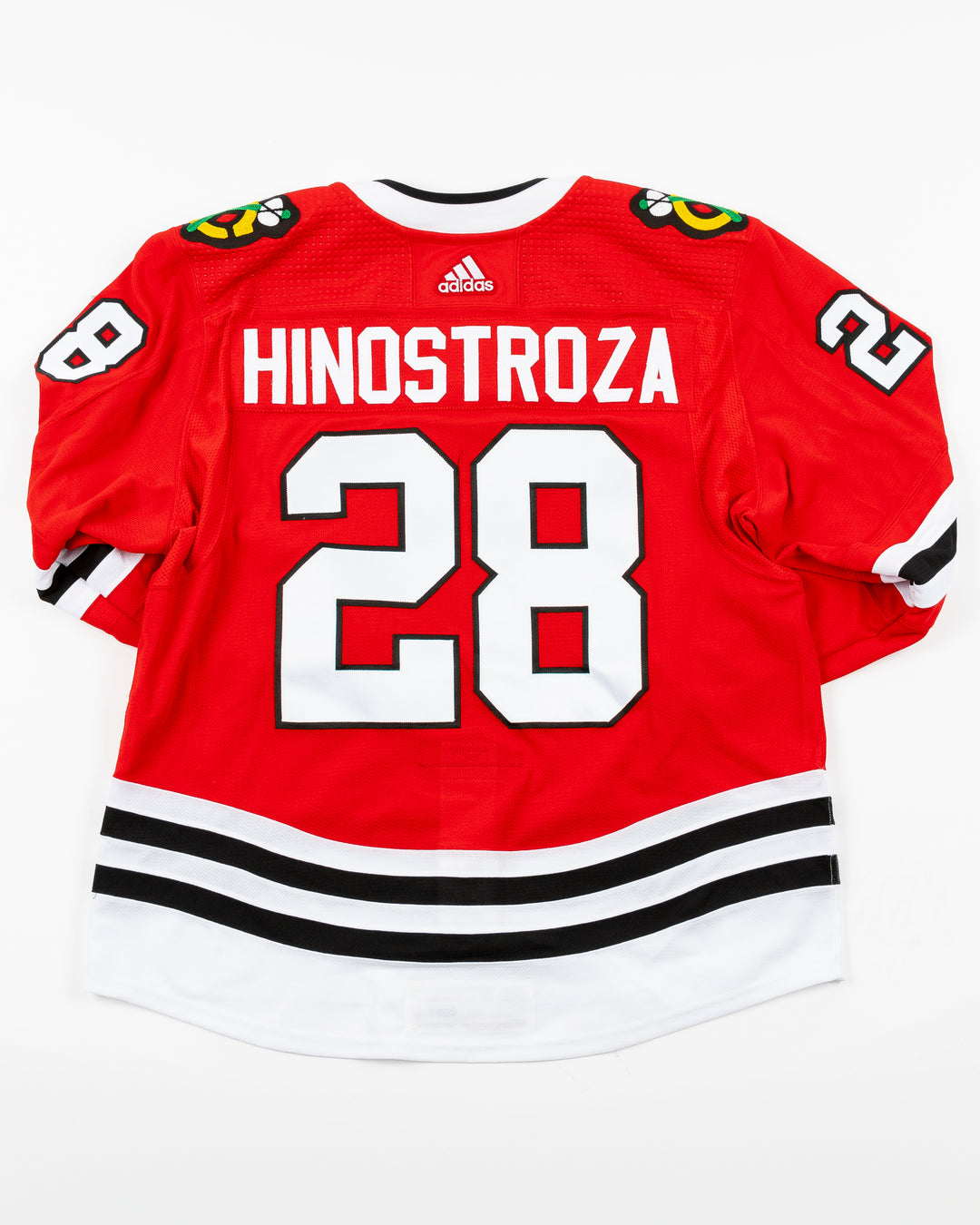 red Chicago Blackhawks home jersey with Vinnie Hinostroza name and number - back lay flat