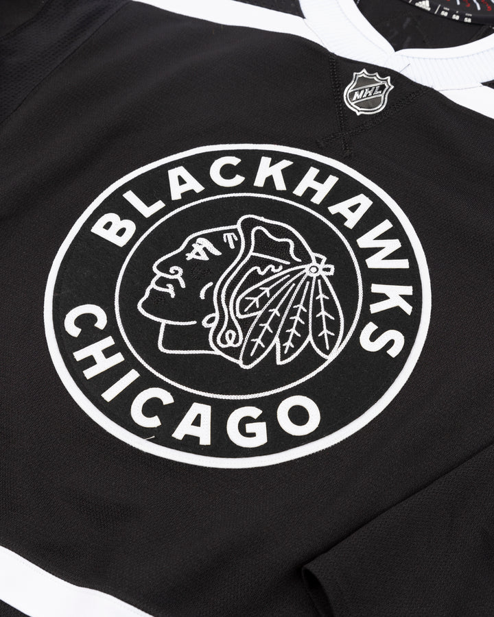 black alternate team-issued Chicago Blackhawks jersey of former player Kirby Dach - front detail lay flat