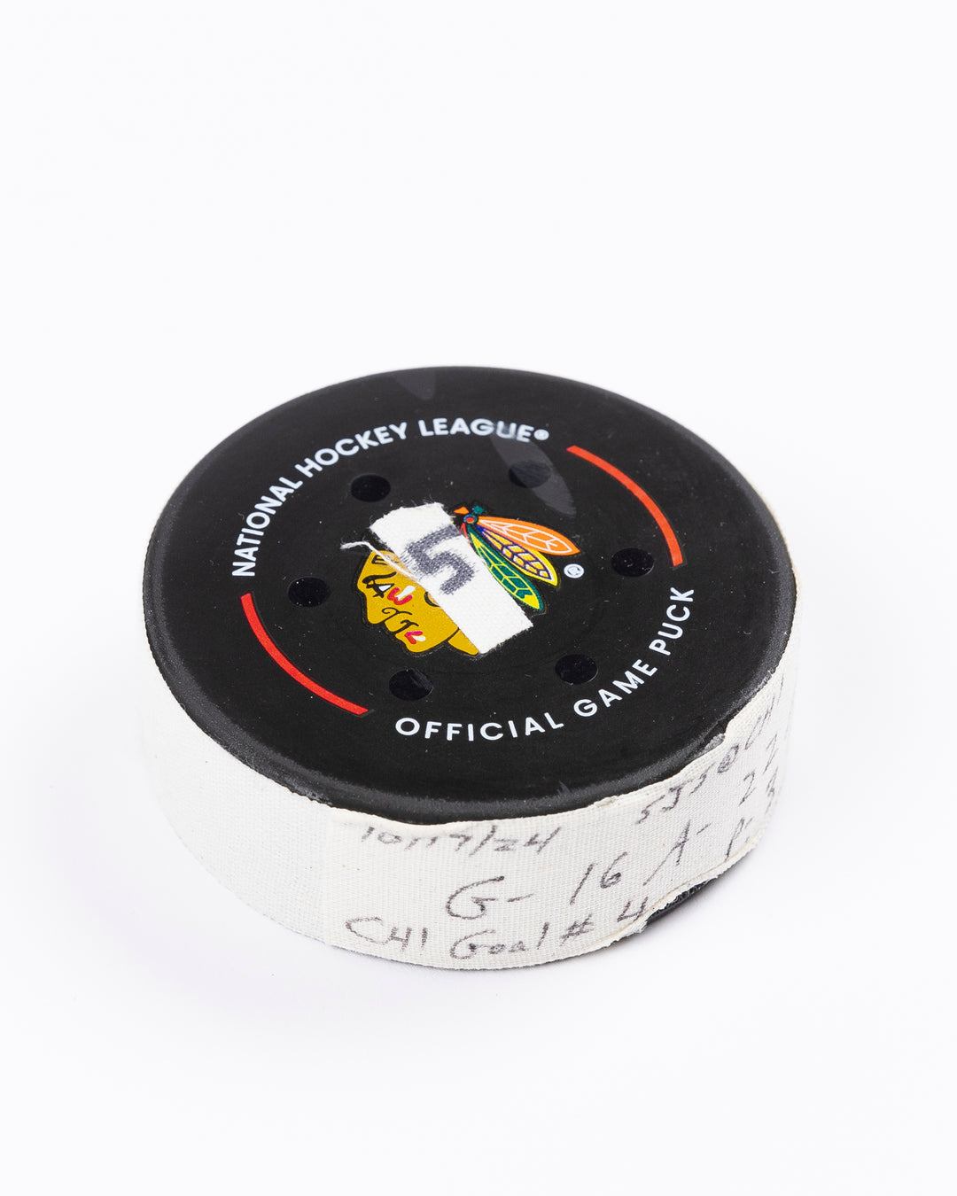 game-used hockey goal puck scored by Chicago Blackhawks player Jason Dickinson - front angled lay flat