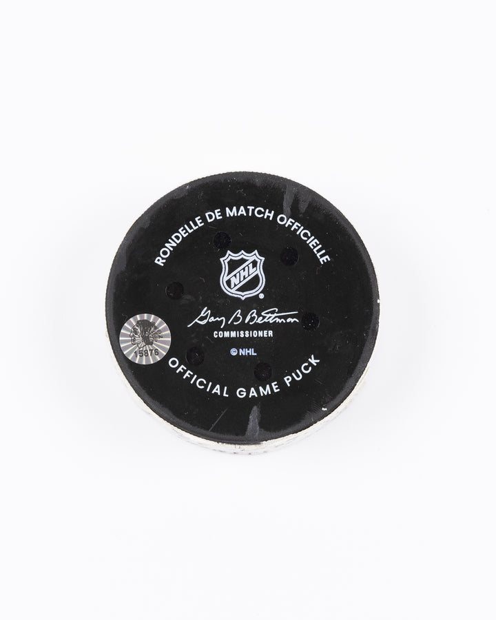 game-used hockey goal puck scored by Chicago Blackhawks player Jason Dickinson - back lay flat