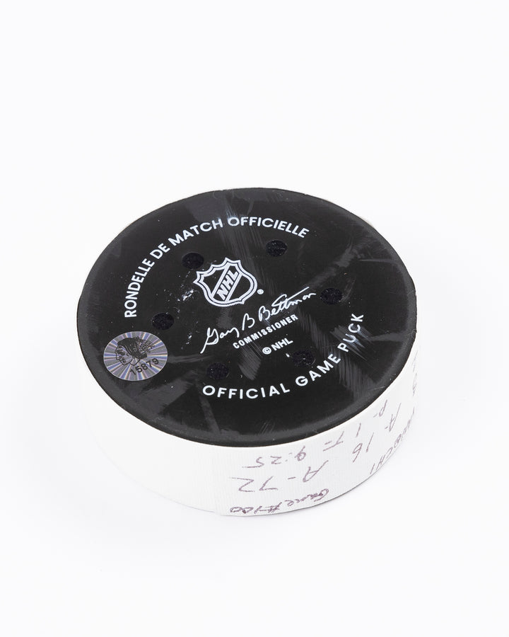 game used hockey goal puck scored by Chicago Blackhawks player Ryan Donato during game on October 22, 2024 - back angled lay flat