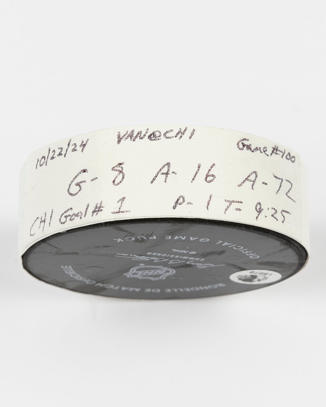 game used hockey goal puck scored by Chicago Blackhawks player Ryan Donato during game on October 22, 2024 - side lay flat