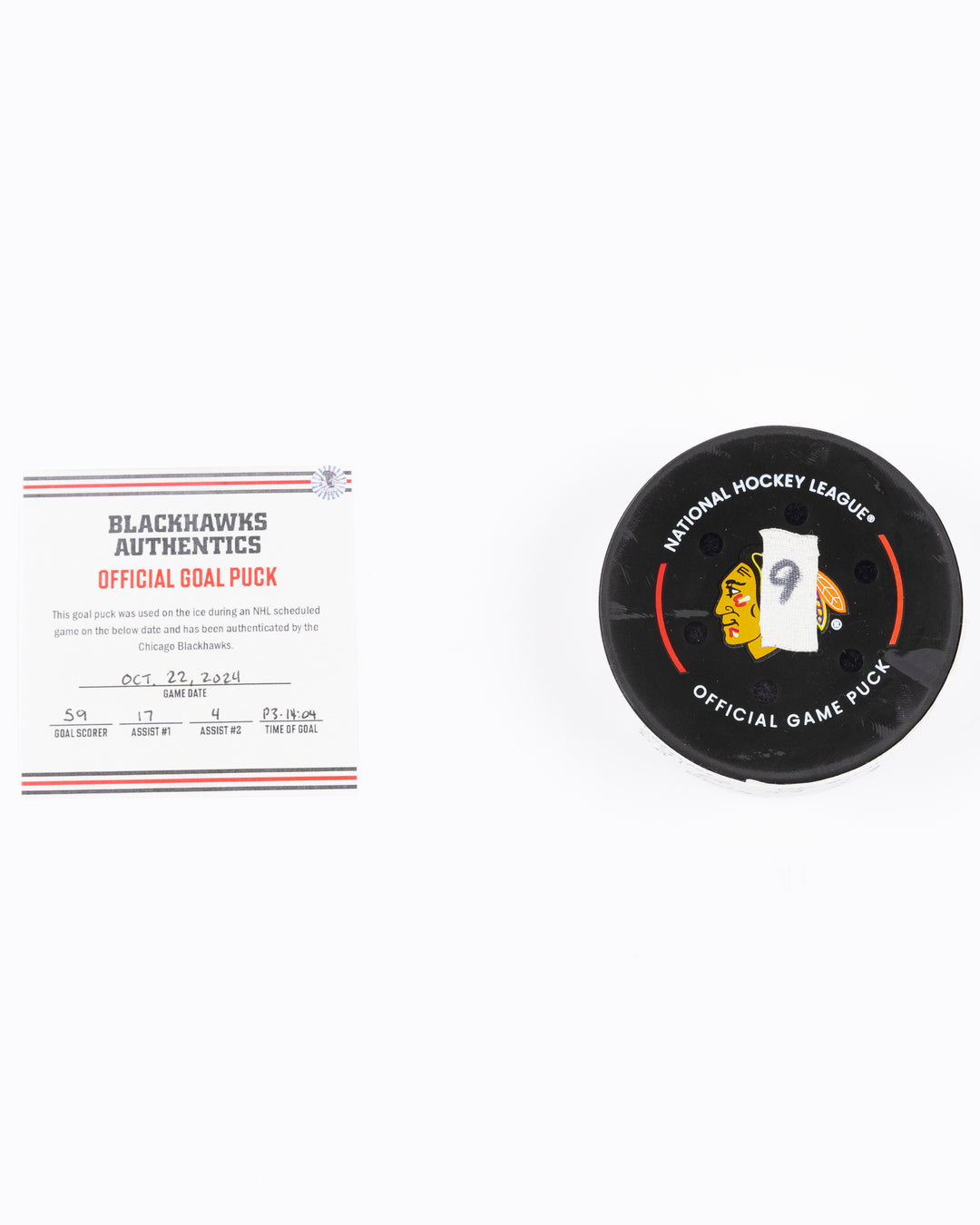 game used hockey goal puck scored by Chicago Blackhawks player Tyler Bertuzzi during game on October 22, 2024 - front lay flat with certificate