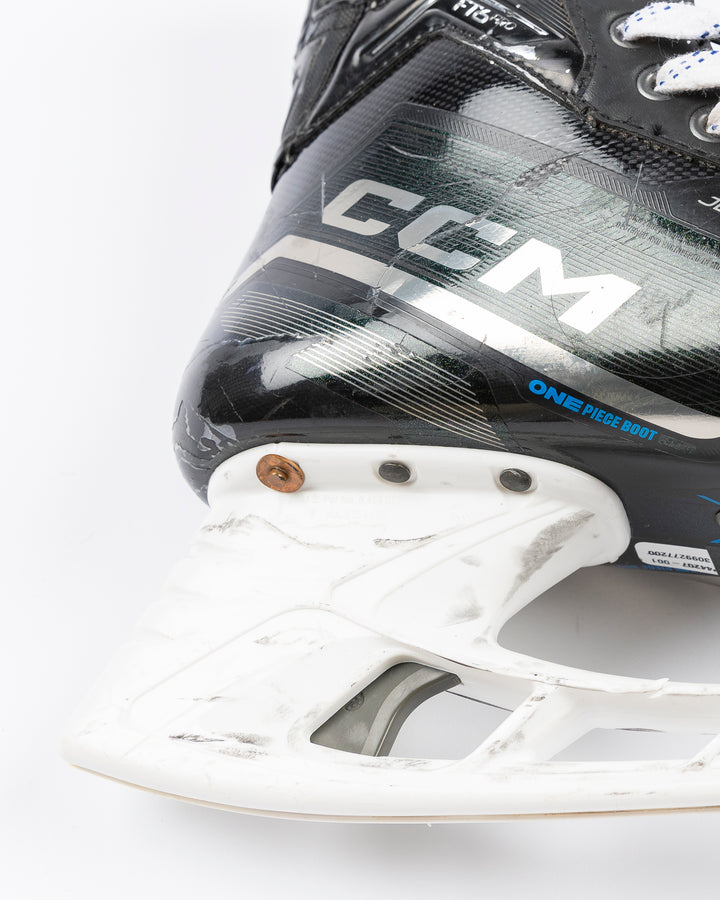 black CCM hockey skates worn and used by Chicago Blackhawks player Jason Dickinson - blade detail lay flat