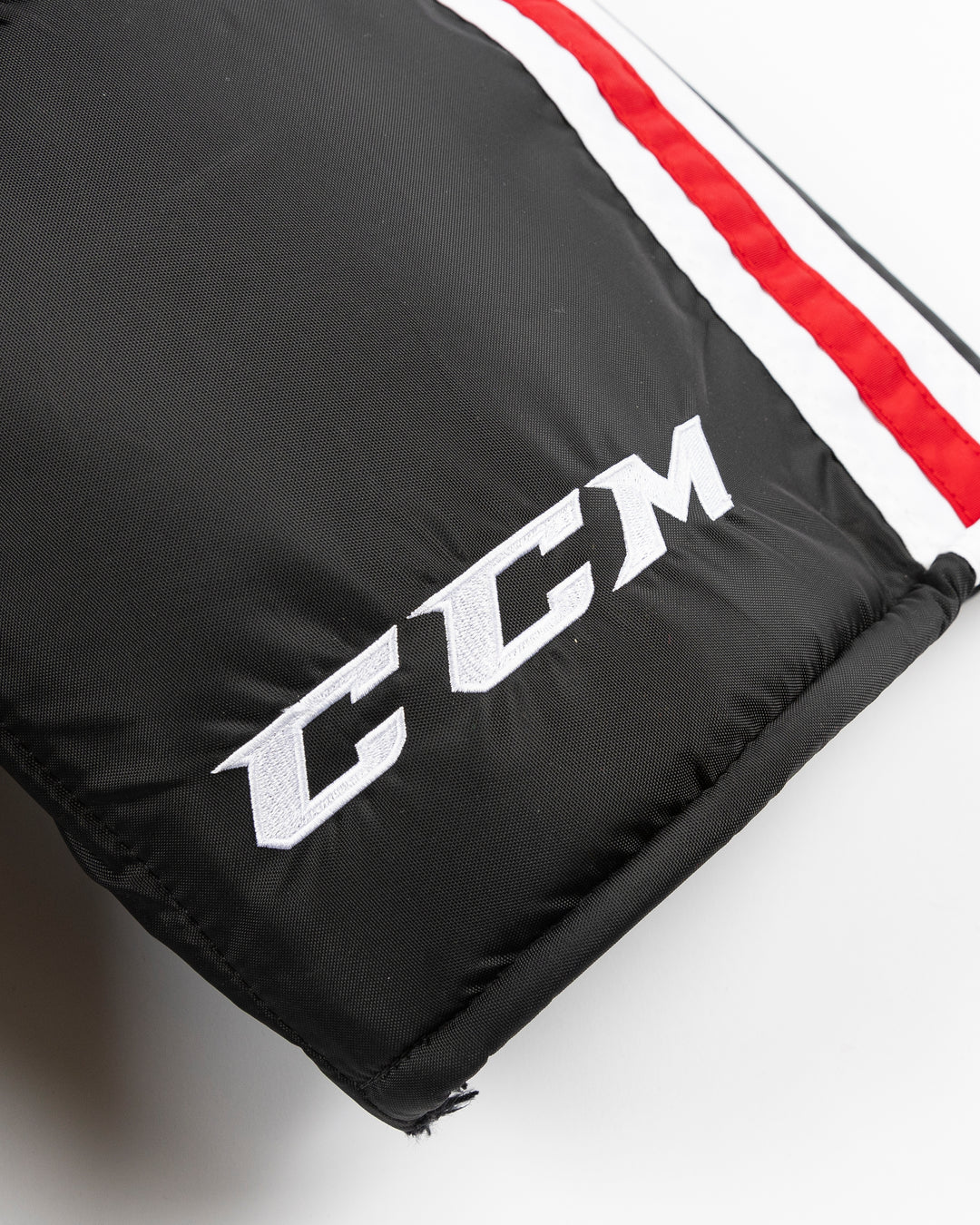 black CCM hockey pants used by unspecified Chicago Blackhawks player - logo detail lay flat