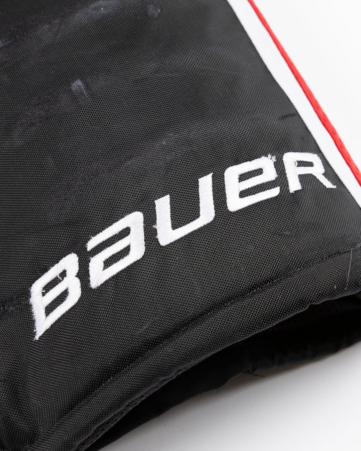 black Bauer hockey pants used by unspecified Chicago Blackhawks player - logo detail lay flat