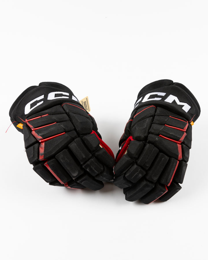 black CCM hockey gloves used by Chicago Blackhawks player Philipp Kurashev - front lay flat