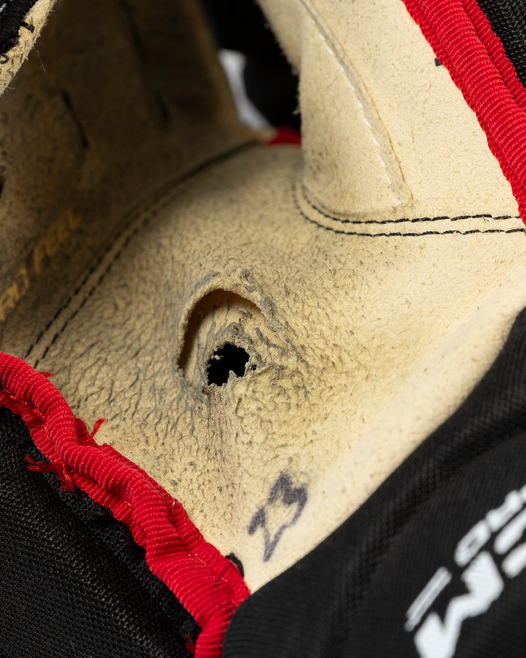 black CCM hockey gloves used by Chicago Blackhawks player Philipp Kurashev - hole detail lay flat