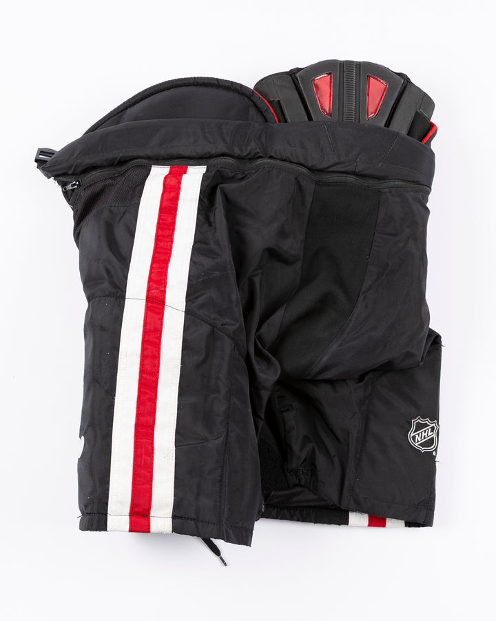 black CCM hockey pants used by Chicago Blackhawks player Ryan Donato - back lay flat