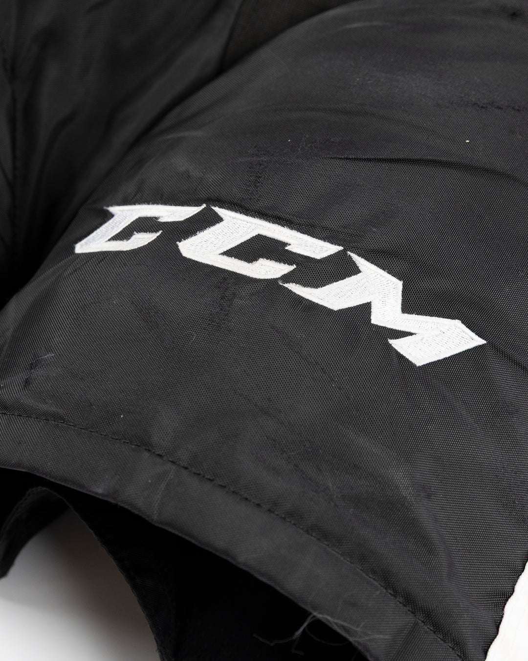 black CCM hockey pants used by Chicago Blackhawks player Jason Dickinson - CCM detail lay flat