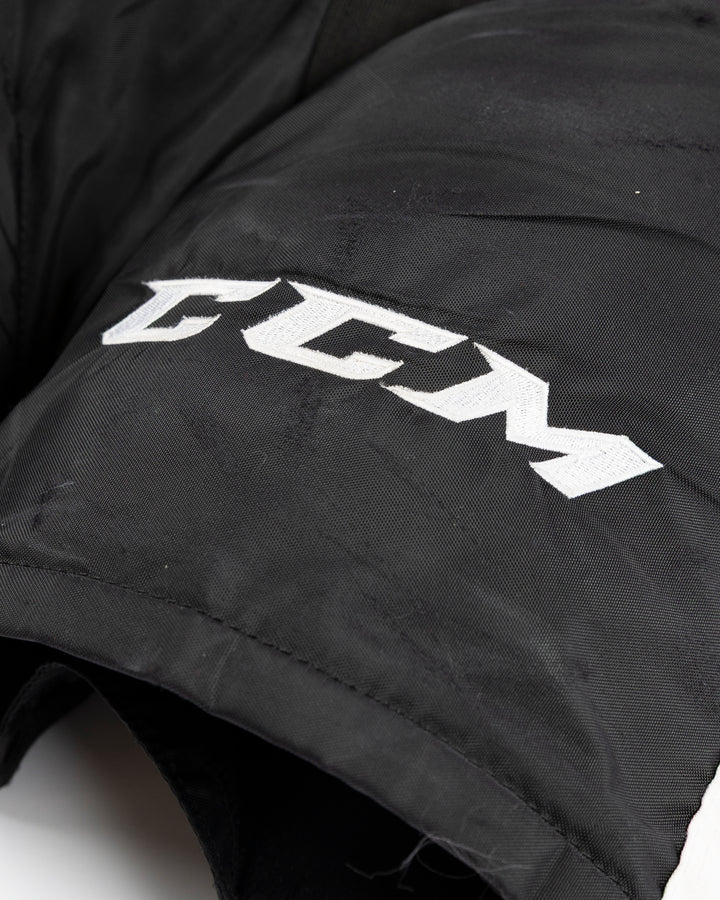 black CCM hockey pants used by Chicago Blackhawks player Jason Dickinson - CCM detail lay flat