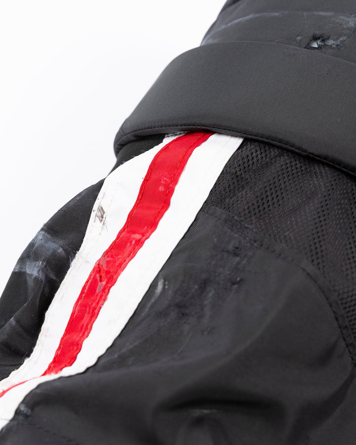 black CCM hockey pants used by Chicago Blackhawks player Jason Dickinson - alt distressing detail lay flat