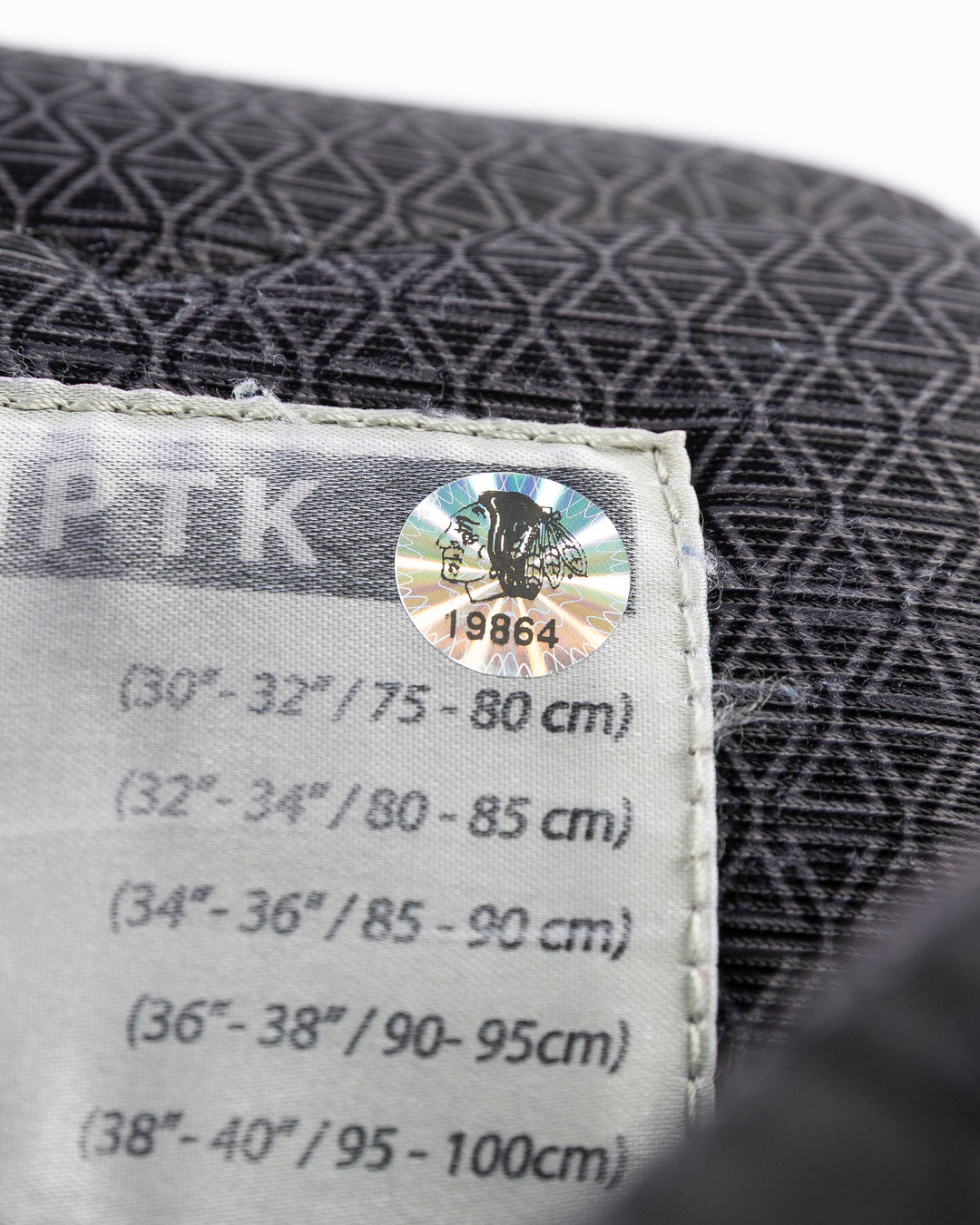 black CCM hockey pants used by Chicago Blackhawks player Jason Dickinson - hologram sticker detail lay flat