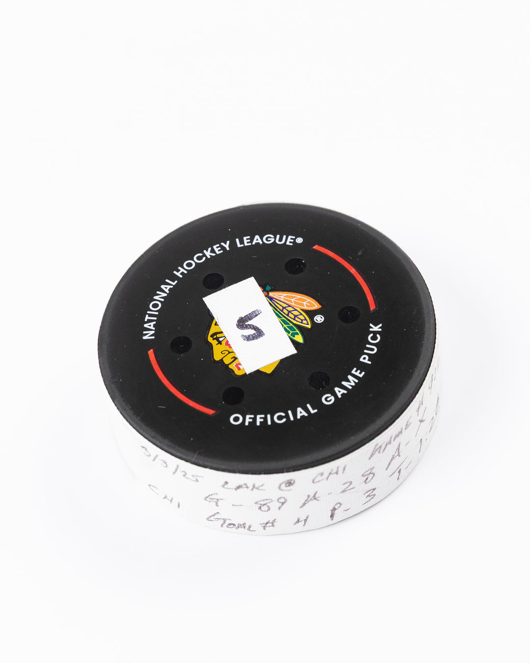 official game used goal hockey puck scored by Chicago Blackhawks player Andreas Athanasiou - front angle lay flat