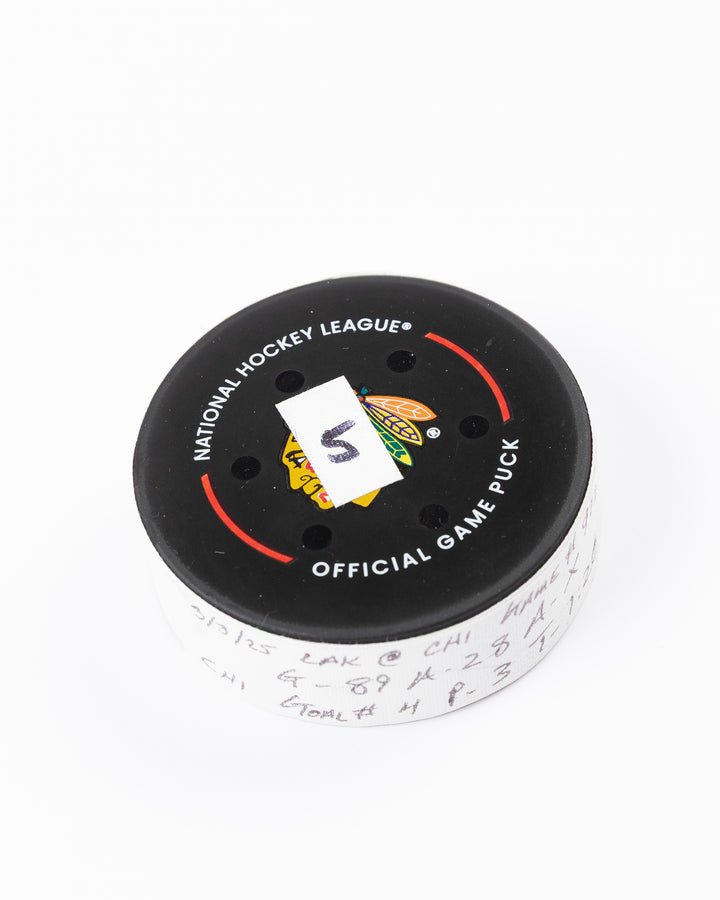official game used goal hockey puck scored by Chicago Blackhawks player Andreas Athanasiou - front angle lay flat