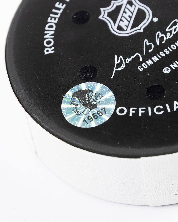 official game used goal hockey puck scored by Chicago Blackhawks player Andreas Athanasiou - hologram sticker detail lay flat