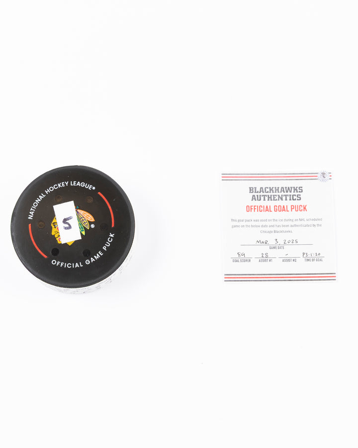 official game used goal hockey puck scored by Chicago Blackhawks player Andreas Athanasiou - front lay flat of puck and certificate side by side