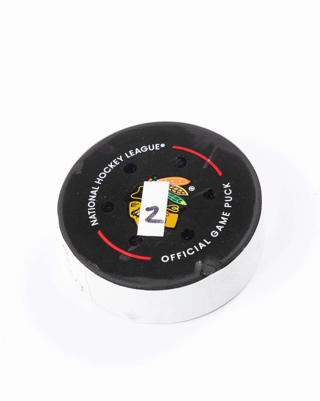 game used hockey goal puck scored by Chicago Blackhawks player Tyler Bertuzzi - front angle lay flat