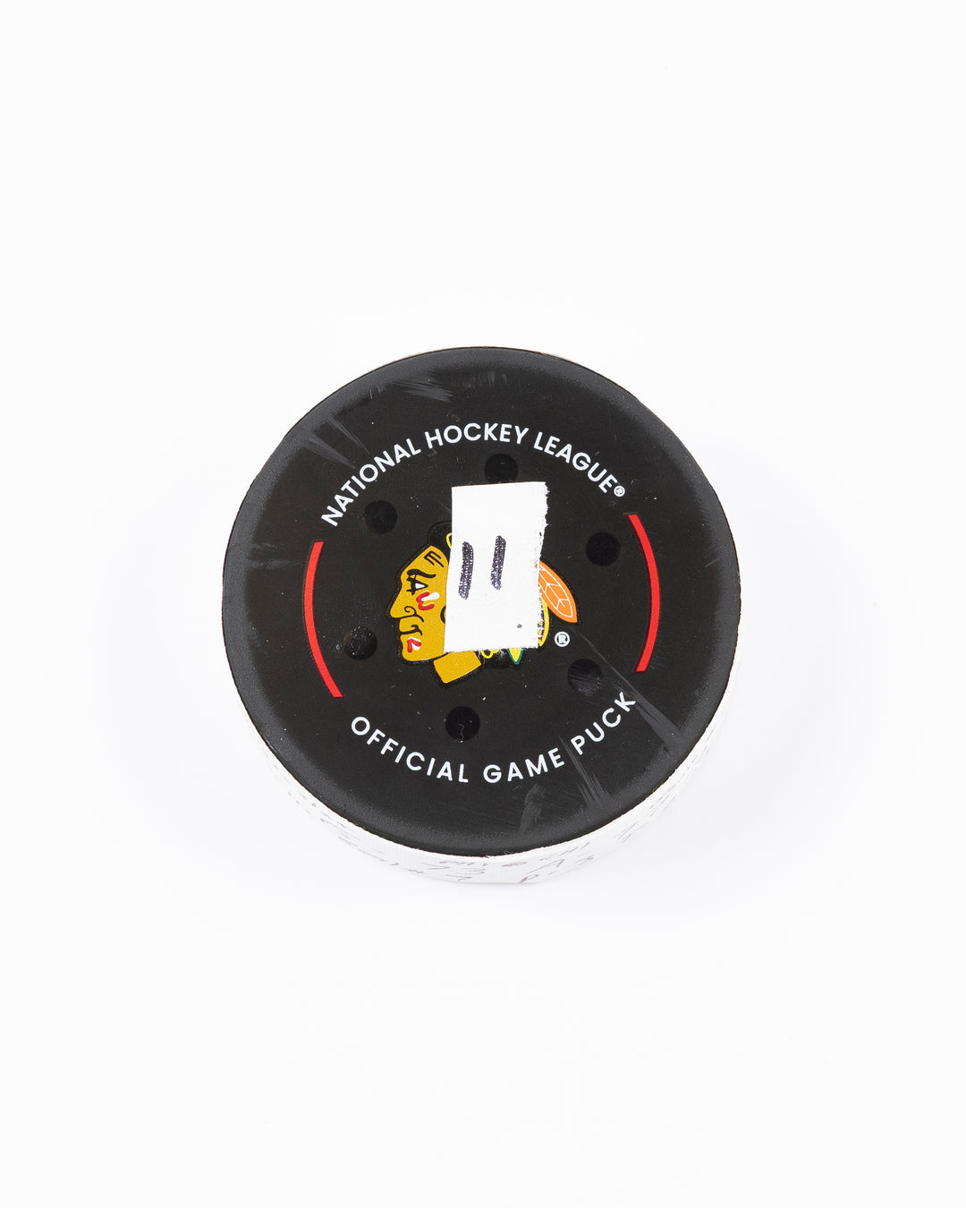 official game used hockey goal puck used by Chicago Blackhawks player Lukas Reichel - front lay flat