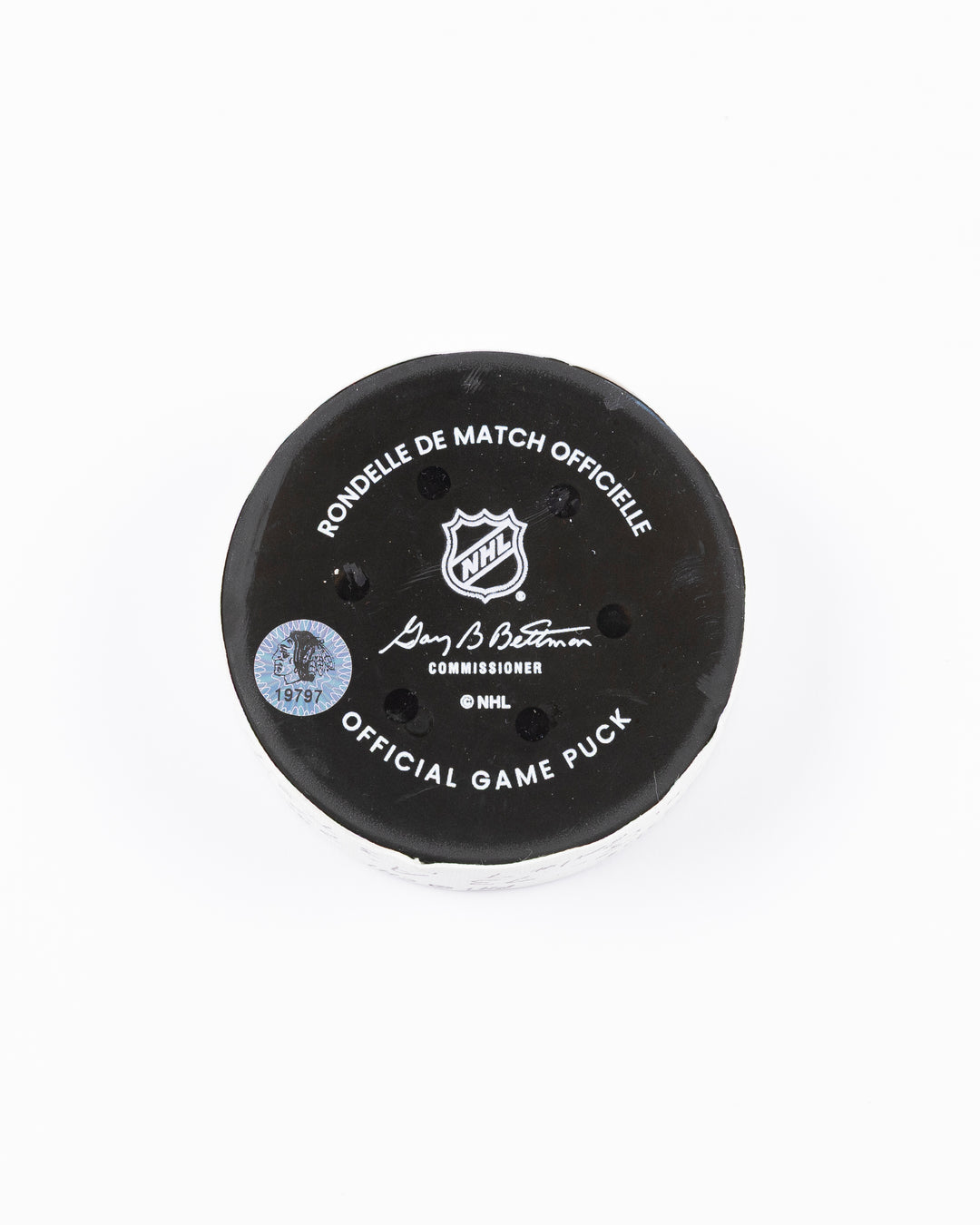 official game used hockey goal puck used by Chicago Blackhawks player Lukas Reichel - back lay flat