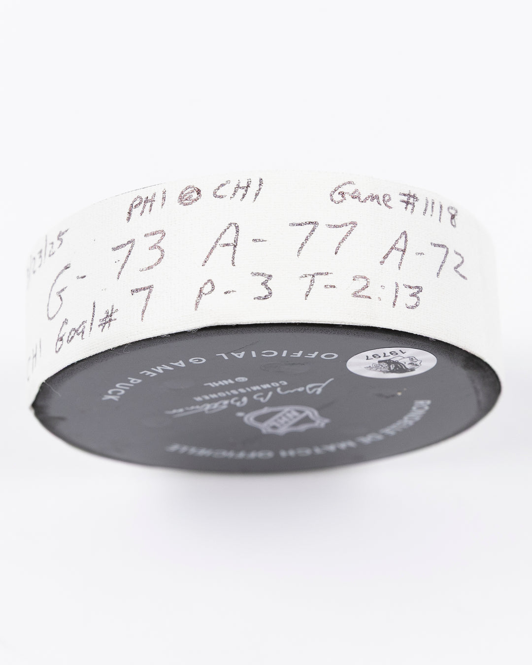 official game used hockey goal puck used by Chicago Blackhawks player Lukas Reichel - tape detail lay flat