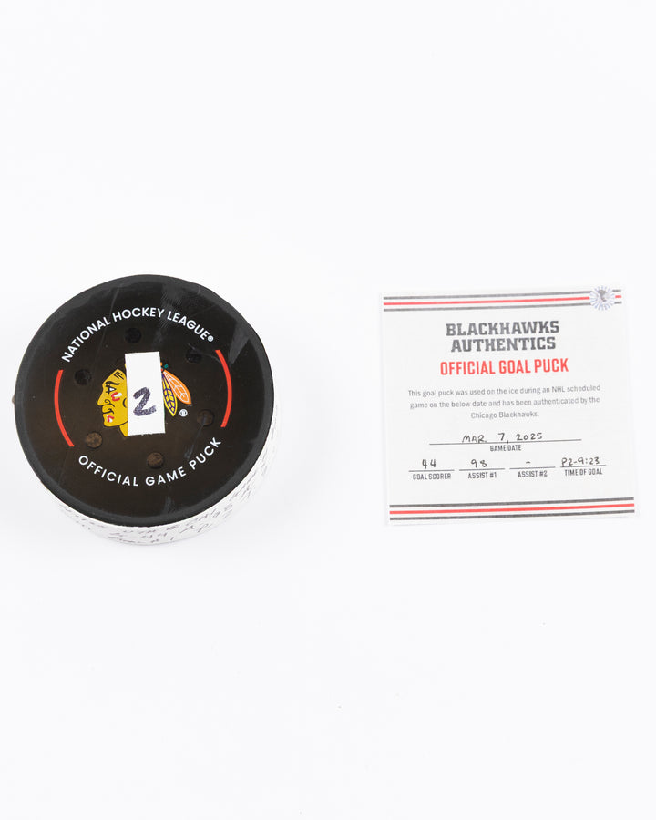 official game used hockey goal puck scored by Chicago Blackhawks player Wyatt Kaiser - front lay flat puck and certificate