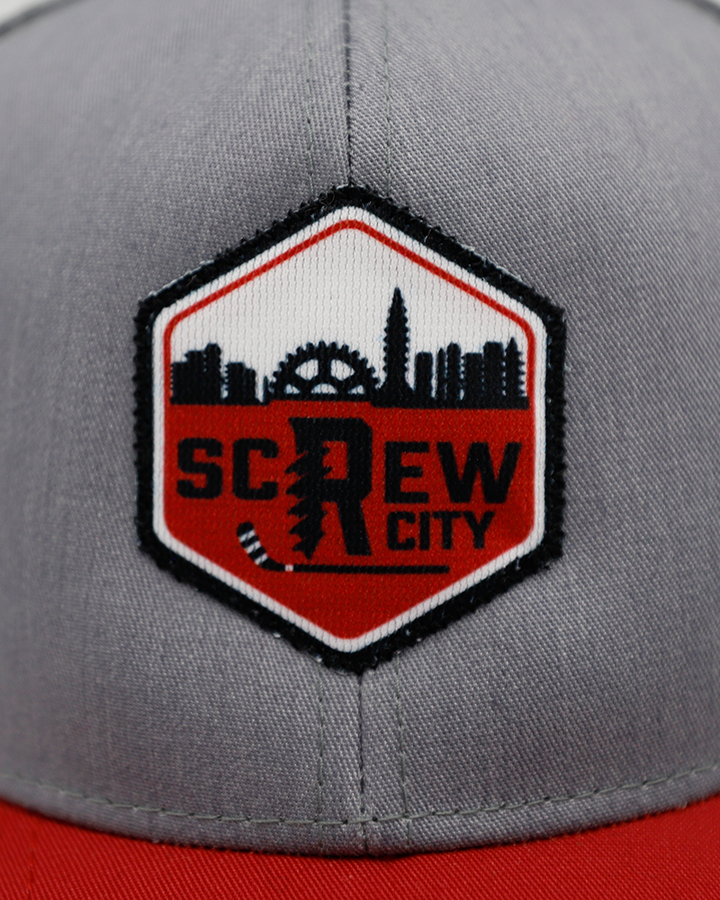 black grey and red trucker hat with Rockford IceHogs Screw City hexagon logo patch on front - front detail lay flat