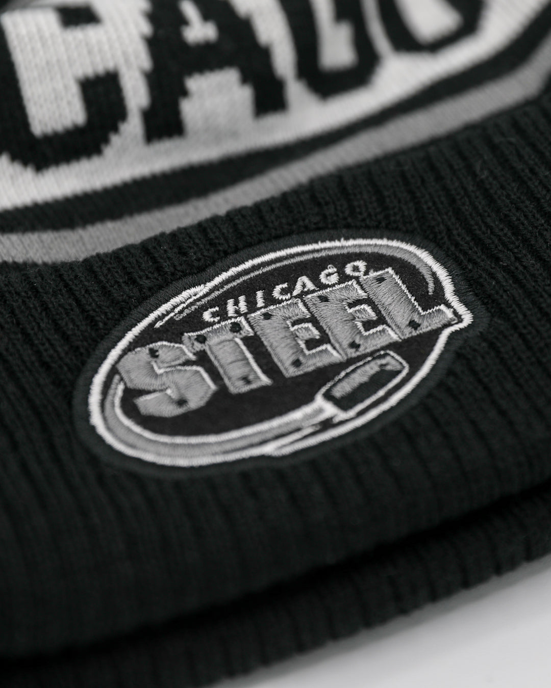 black white and grey Legacy beanie with two tone pom on top and Chicago Steel logo embroidered on front cuff - front detail lay flat