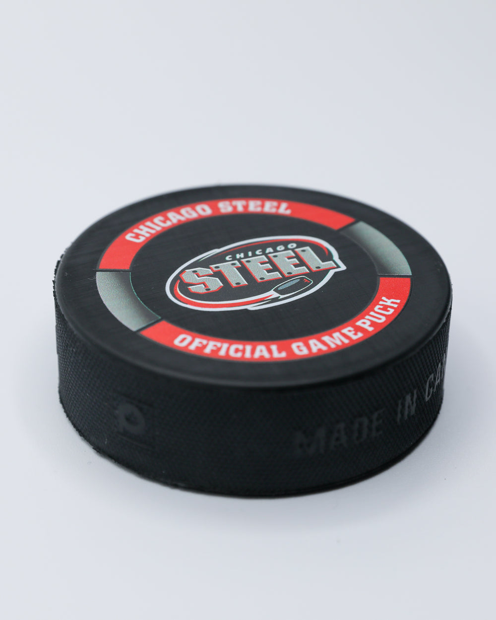 official game hockey puck of the Chicago Steel - angled lay flat