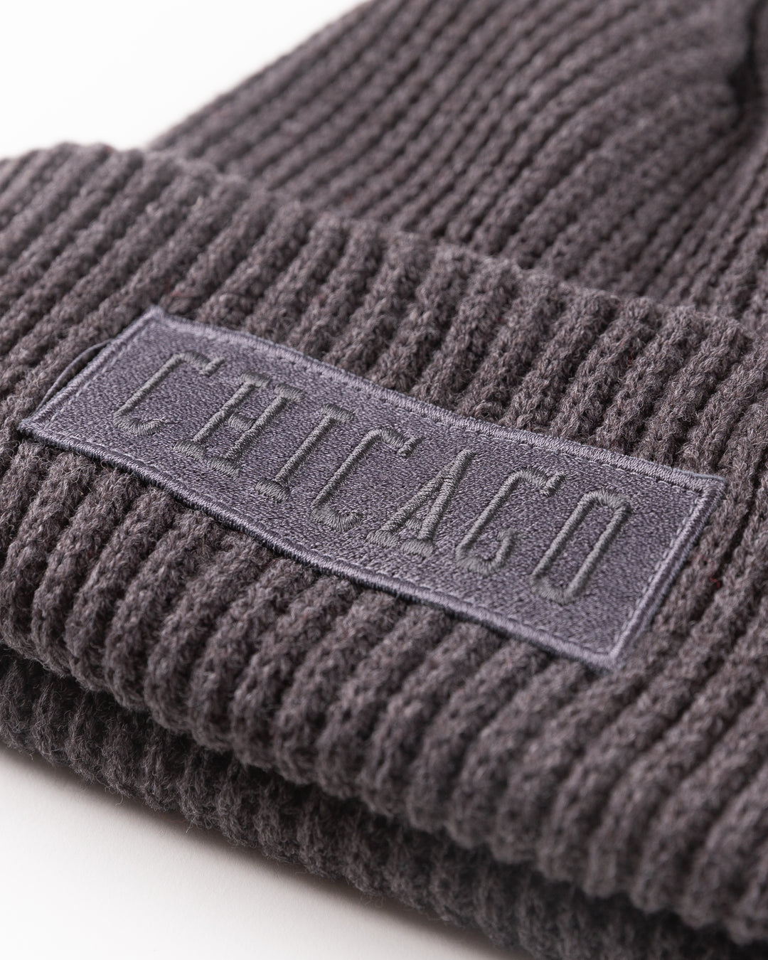 grey ribbed CCM knit hat with Chicago wordmark patch and Chicago Blackhawks primary logo tag on cuff - detail lay flat