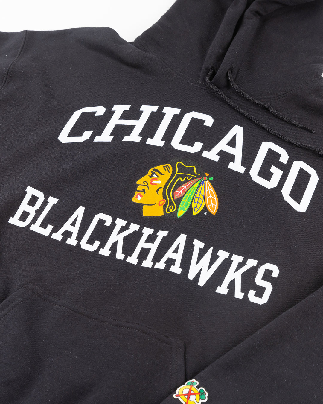 black Chicago Blackhawks hoodie with wordmark and primary logo on chest and secondary logo on left wrist - detail front lay flat