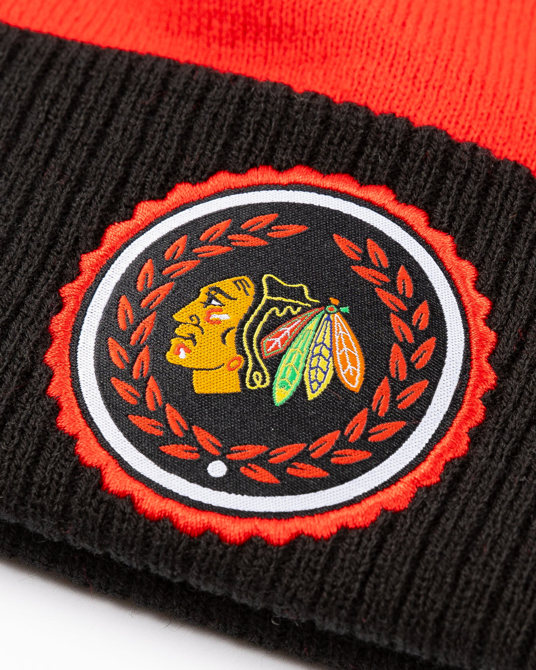 red and black adidas knit pom hat with Chicago Blackhawks primary logo collegiate inspired patch on cuff - detail lay flat