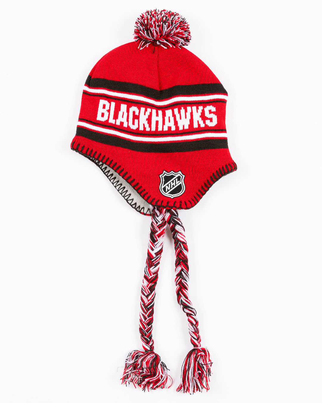 red youth knit hat with tassels and Chicago Blackhawks wordmark on front and Chicago Blackhawks primary logo and NHL logo embroidered on sides - alt side lay flat