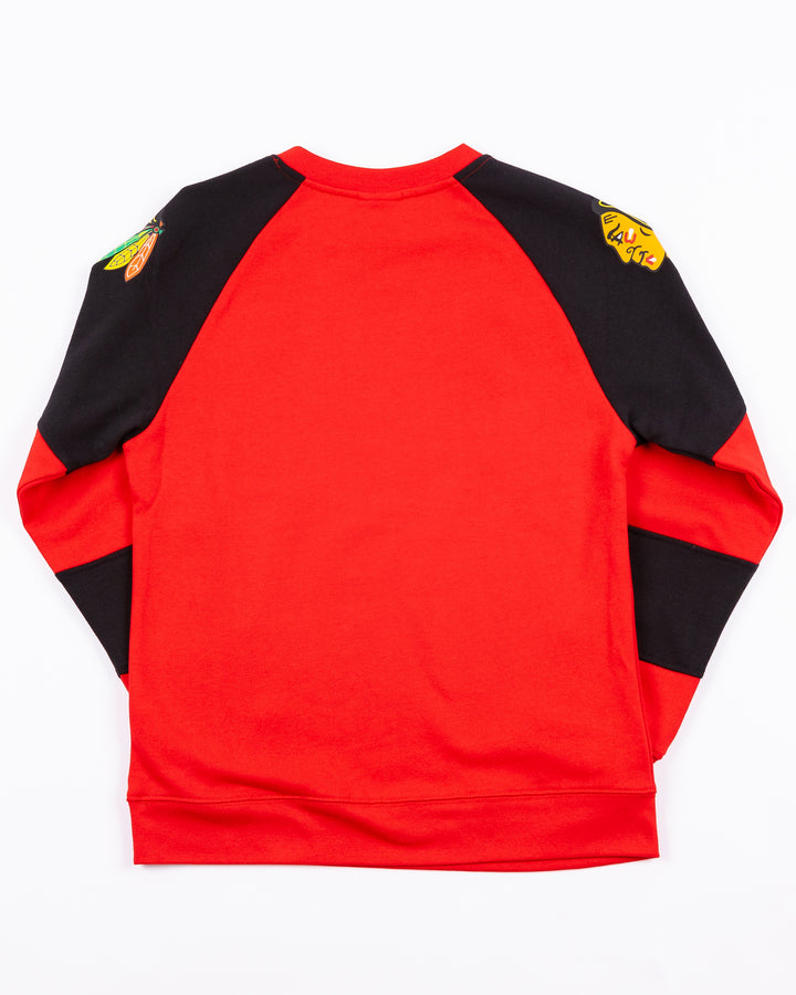 red and black youth crewneck with Chicago Blackhawks wordmark across front and primary logo on both shoulders - back lay flat