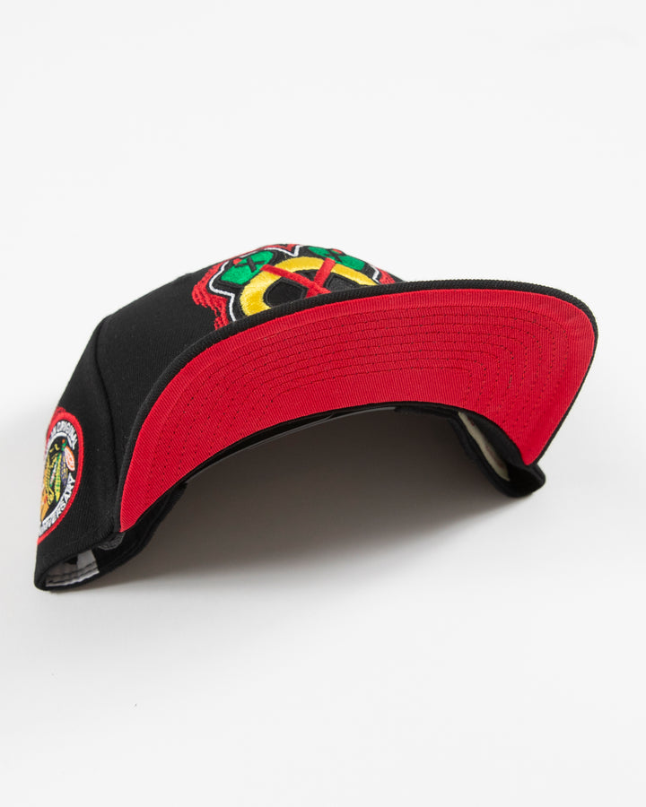 black Mitchell & Ness snapback with Chicago Blackhawks secondary logo embroidered on front and primary logo patch embroidered on right side - under brim detail lay flat 