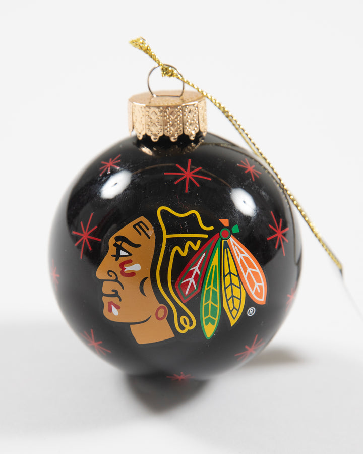 black holiday ornament with Chicago Blackhawks primary logo and red snowflake designs all over - front lay flat