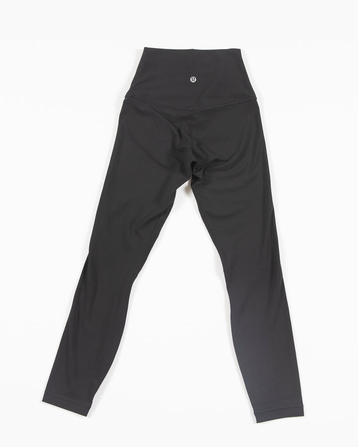 Black lululemon leggings with white tonal Chicago Blackhawks primary logo on left thigh - back lay flat