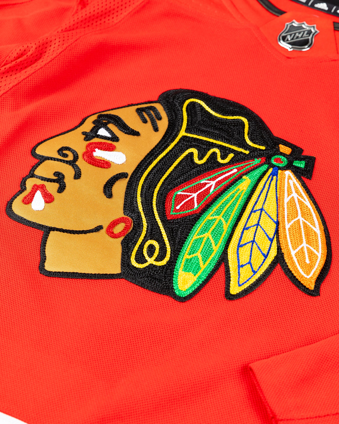 red adidas Chicago Blackhawks jersey with Lukas Reichel name and number stitched - front detail lay flat