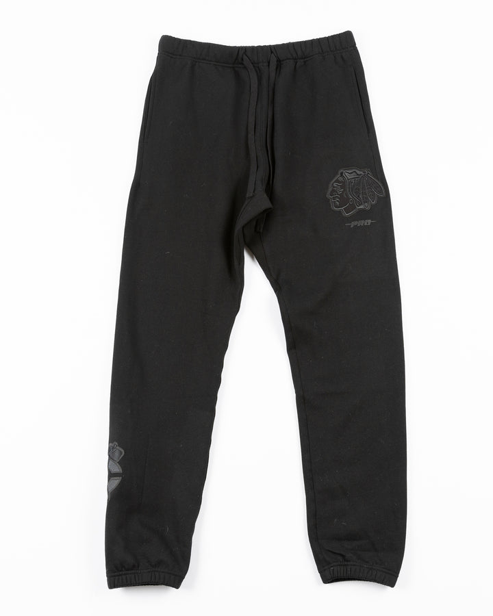 black Pro Standard sweatpants with Chicago Blackhawks embroidered tonal logos on legs - front lay flat