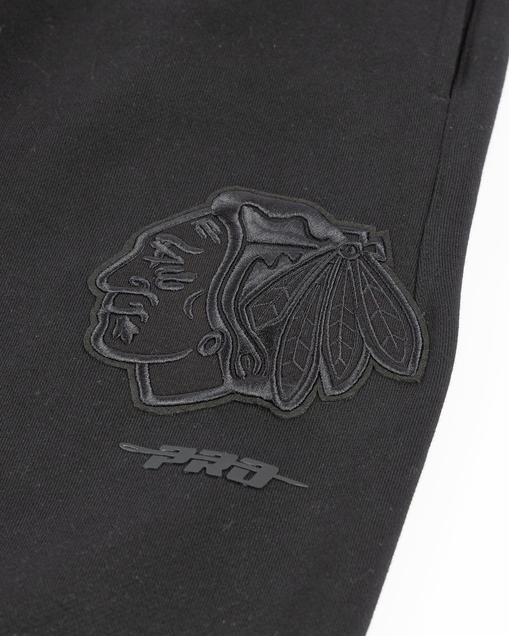 black Pro Standard sweatpants with Chicago Blackhawks embroidered tonal logos on legs - detail lay flat
