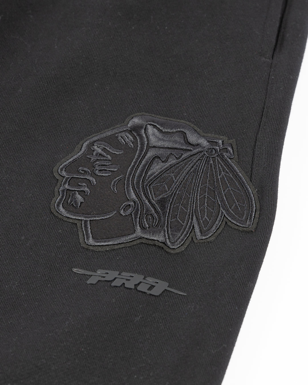 black Pro Standard sweatpants with Chicago Blackhawks embroidered tonal logos on legs - detail lay flat