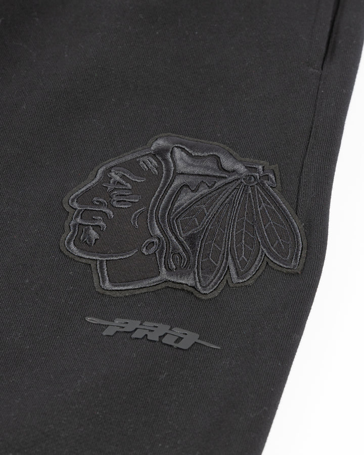 black Pro Standard sweatpants with Chicago Blackhawks embroidered tonal logos on legs - detail lay flat