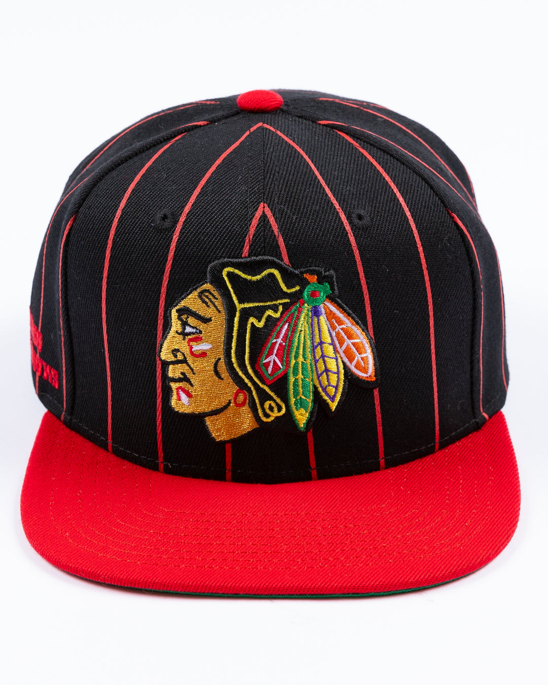 black and red Mitchell & Ness snapback cap with embroidered Chicago Blackhawks primary logo embroidered on front - front lay flat