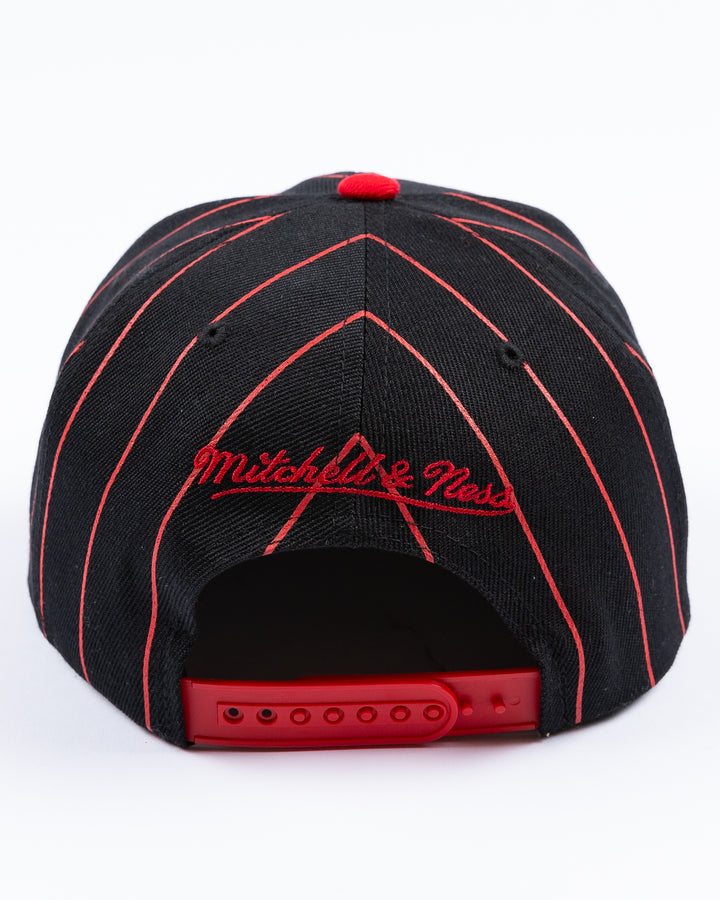 black and red Mitchell & Ness snapback cap with embroidered Chicago Blackhawks primary logo embroidered on front - back lay flat