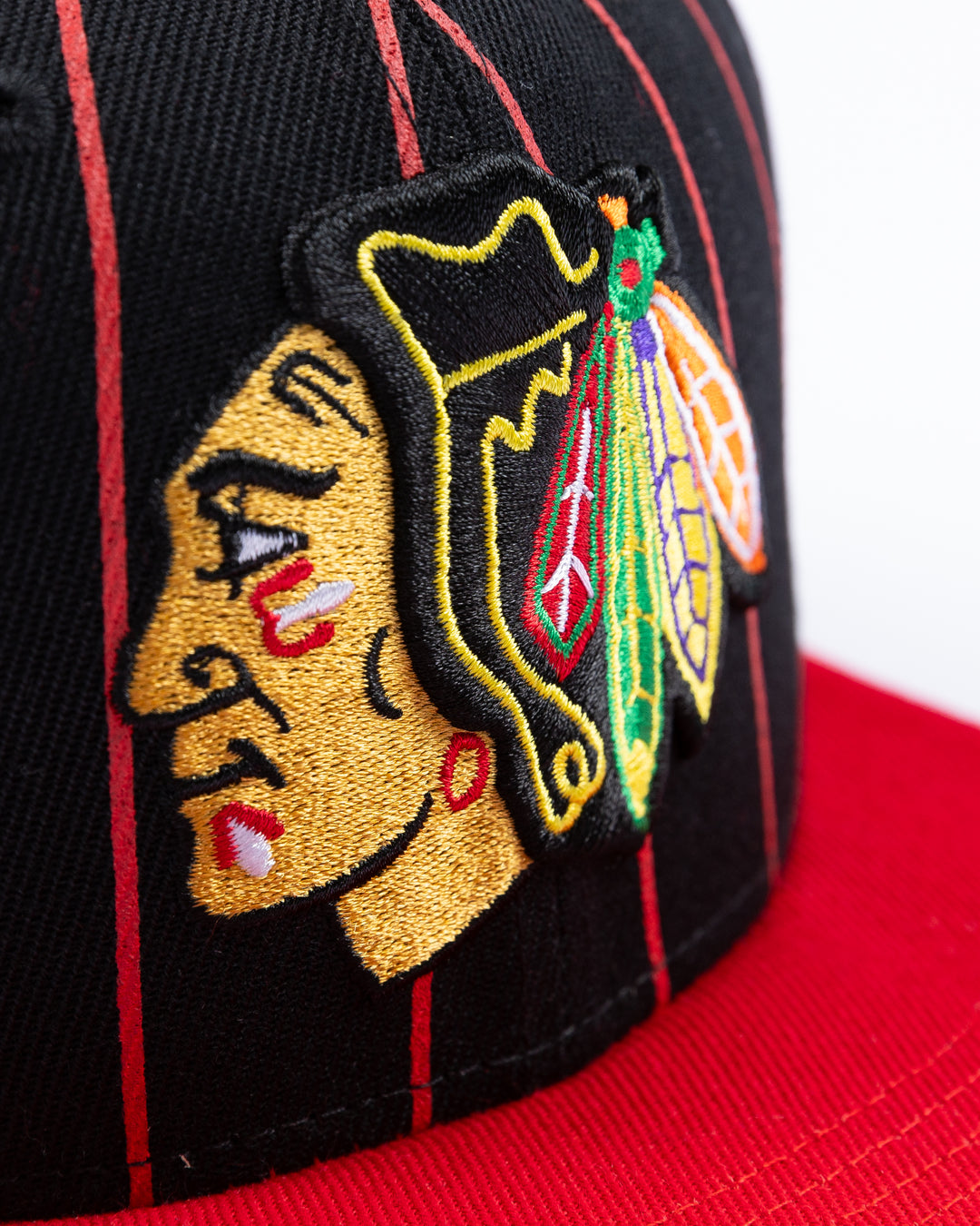 black and red Mitchell & Ness snapback cap with embroidered Chicago Blackhawks primary logo embroidered on front - detail lay flat