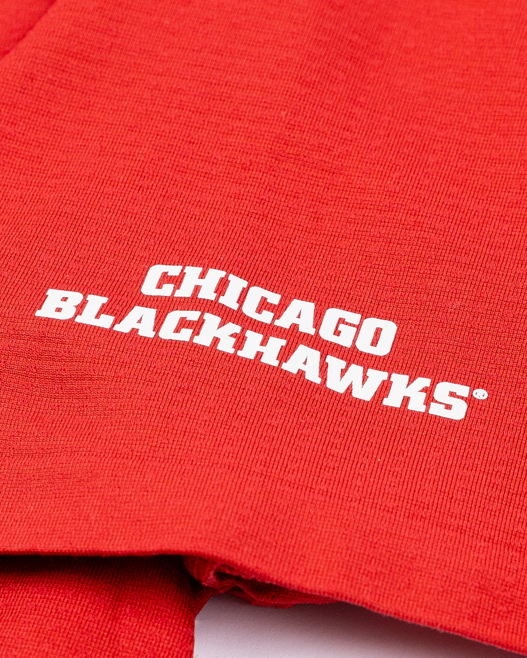 red lululemon polo with Chicago Blackhawks wordmark on left shoulder - detail lay flat