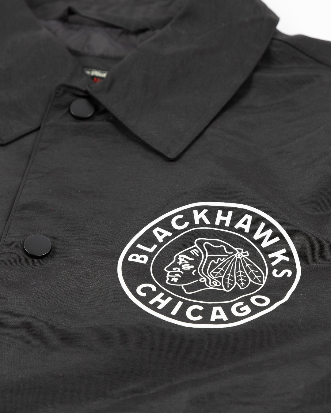 black American Needle coaches jacket with vintage Chicago Blackhawks logo on front left chest and graphic on back - front detail lay flat