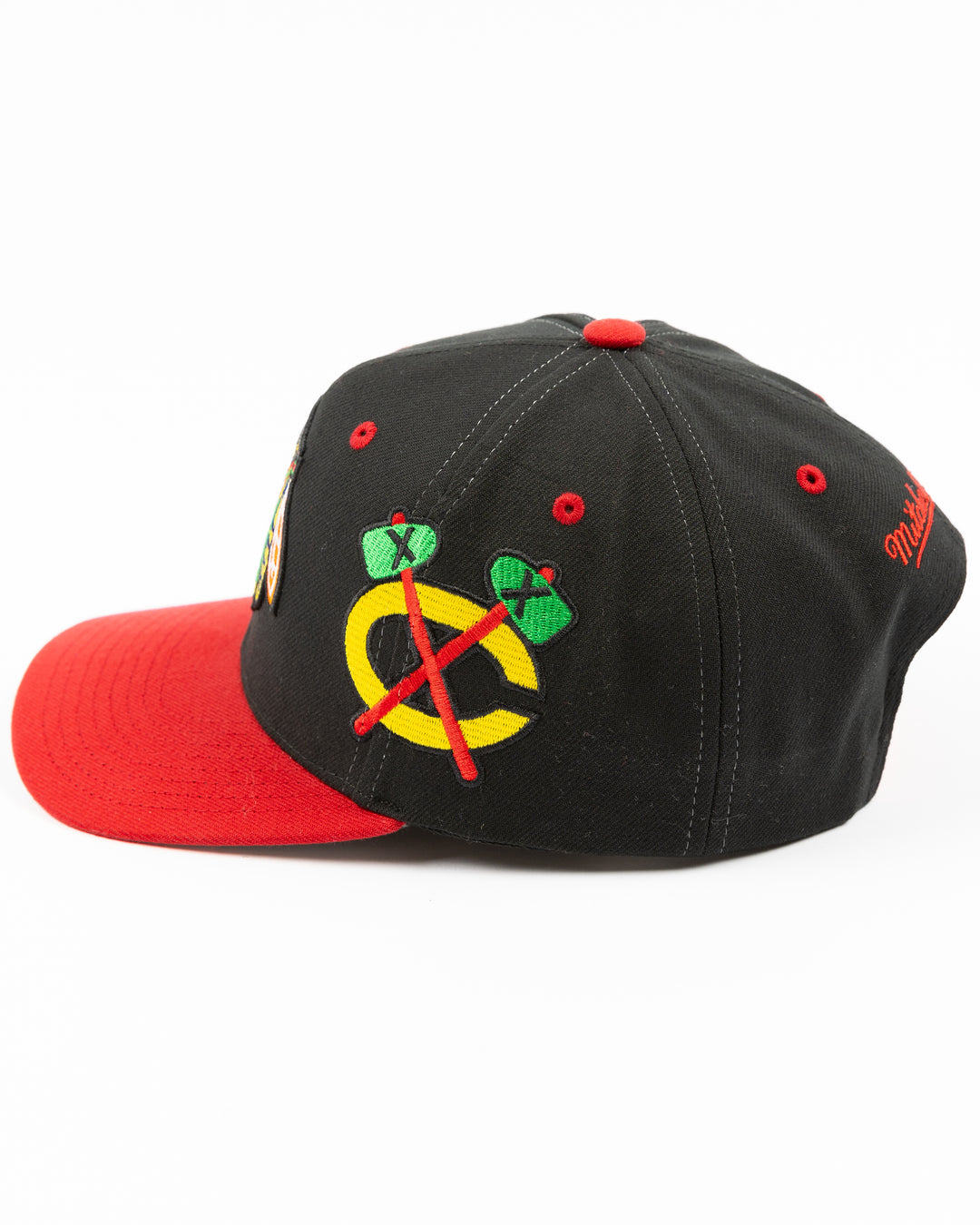 black and red Mitchell & Ness snapback with Chicago Blackhawks primary logo on front, secondary logo on left side and wordmark Chicago on right - left side lay flat