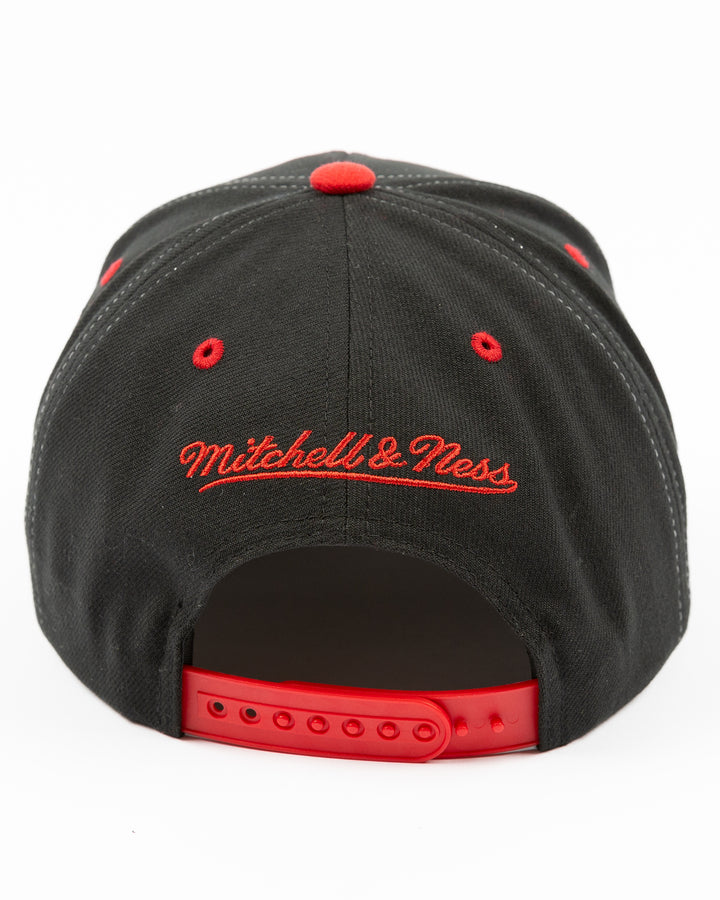 black and red Mitchell & Ness snapback with Chicago Blackhawks primary logo on front, secondary logo on left side and wordmark Chicago on right - back lay flat