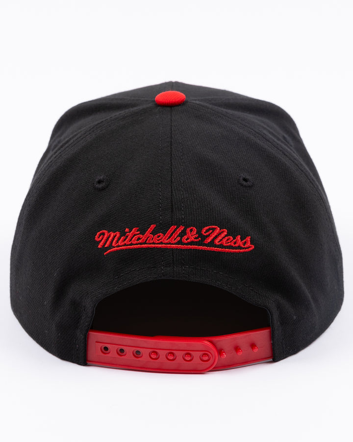 two tone red and black Mitchell &amp; Ness snapback with embroidered primary logo on front - back lay flat
